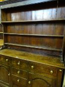AN EARLY 19th CENTURY CAERNARFONSHIRE OAK DRESSER having a three shelf rack over a base having