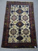 AN OLD BALUCHI CARPET RUNNER having cream ground central panel with traditional motifs and double