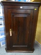 A VINTAGE OAK WALL HANGING CORNER CUPBOARD with single raised panel door and interior shelves, 96