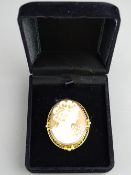 A TEN CARAT GOLD MOUNTED CARVED CAMEO PENDANT BROOCH, 4.25 cms long, a chain loop with swivel