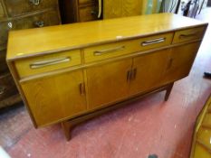 A G-PLAN TEAK LONG SIDEBOARD having three frieze drawers and four cupboard doors, 85 cms high, 152