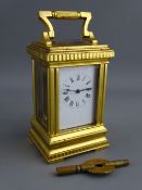 A FRENCH GILT BRASS CASED MINIATURE CARRIAGE CLOCK with white enamel dial set with Roman numerals,