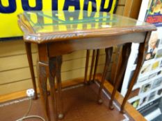 A nest of three coffee tables with tooled leather tops & glass inserts