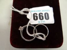 A platinum wedding band with small diamonds together with a half hoop diamond eternity ring,