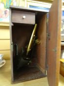 A brass microscope in a mahogany case