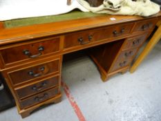 A reproduction pedestal desk with tooled green leather top