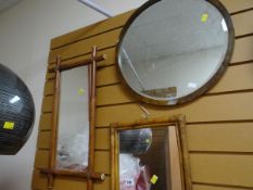 Two bamboo framed mirrors together with another circular bevelled wall mirror