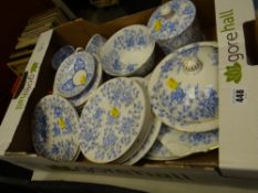 A box of blue & white plates, cups, muffin dish etc