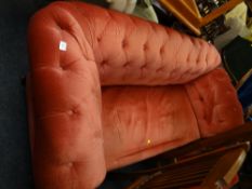 An early twentieth century red velvet button backed drop end sofa