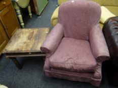 A reproduction loose covered armchair together with a rustic darkwood side table