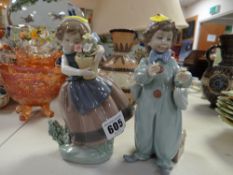 A Lladro figure of a boy dressed as a clown & a similar girl with flowerpot