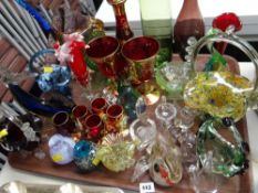 A large tray of various coloured glass items including small animals, vases, gilded decanter &