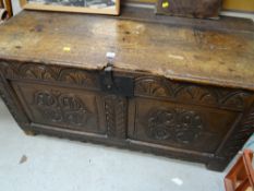 An antique carved oak coffer (distressed)