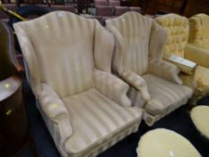 A pair of modern gold Regency striped upholstered wingback armchairs