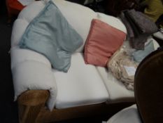 A three-seater rattan rolled arm & back sofa with loose covers