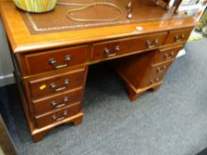 A reproduction pedestal desk with tooled leather top
