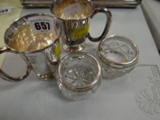A pair of silver mugs, a pair of silver rimmed salts