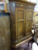 Two door corner cupboard with lower base drawer on raised supports