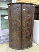 Carved oak bow front hanging wall cupboard