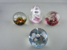 Four glass paperweights, two marked Caithness, one other Scottish maker