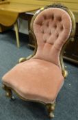 An antique buttoned upholstery spoon back chair with carved rail