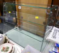A glass counter top three-shelved display cabinet