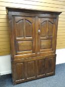 An early nineteenth century oak two-stage press cupboard with panelled base & two cupboard doors