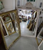 A modern ornate shell-topped bevelled wall mirror together with a modern gilt framed bevelled wall