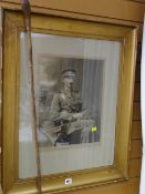 A framed photograph of a military officer together with the swagger stick which features in the