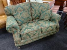 A good quality modern two-seater sofa in green floral fabric