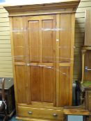 A pine single-door wardrobe with a single-drawer base