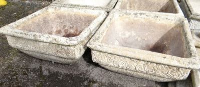 A pair of composite stone square planters on a low plinth (outside)