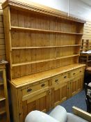 A large pine dresser, three-drawer three-cupboard base & three-shelf rack