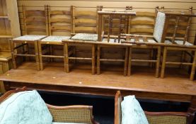 A long narrow pine dining table together with eight modern rush seated ladder back dining chairs (