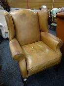 A tan Laura Ashley leather buttoned wingback armchair