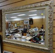 A large modern ornate gilt framed bevelled glass wall mirror