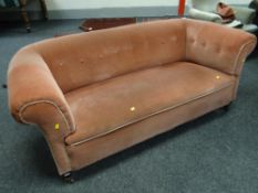 A vintage pink upholstered chesterfield-type button back settee