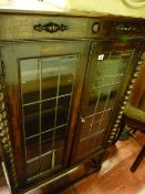 Glazed bookcase on barley twist supports having two leaded glazed doors