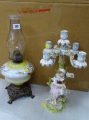 Victorian style oil lamp with glass font and a Continental porcelain figural candelabra showing a