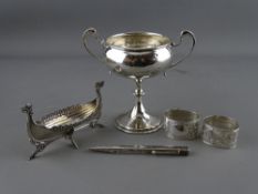 Small silver including a twin handled pedestal cup, a pair of chased decorated napkin rings, a