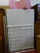 Double divan bed with metal headboards and a pink floral upholstered bedroom chair