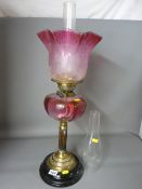 Victorian brass reeded column oil lamp with cranberry tinted glass reservoir and etched shade