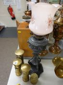 Three ornamental brass postboxes and a cast metal oil lamp with floral decorated pink glass shade