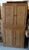 A pair of pine two-door cupboards