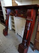 A carved mahogany fire surround