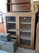 A two-door pine glazed bookcase