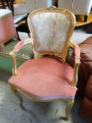A gold painted French-style elbow chair with floral upholstery