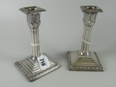 A pair of short hallmarked silver Corinthian candle sticks