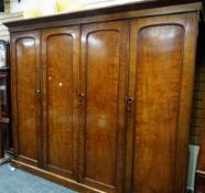 A large antique mahogany four-door wardrobe with press cupboard centre