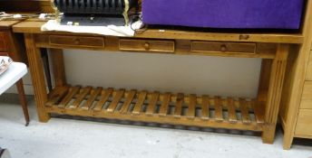 A modern kitchen work table with lower tier & three drawers